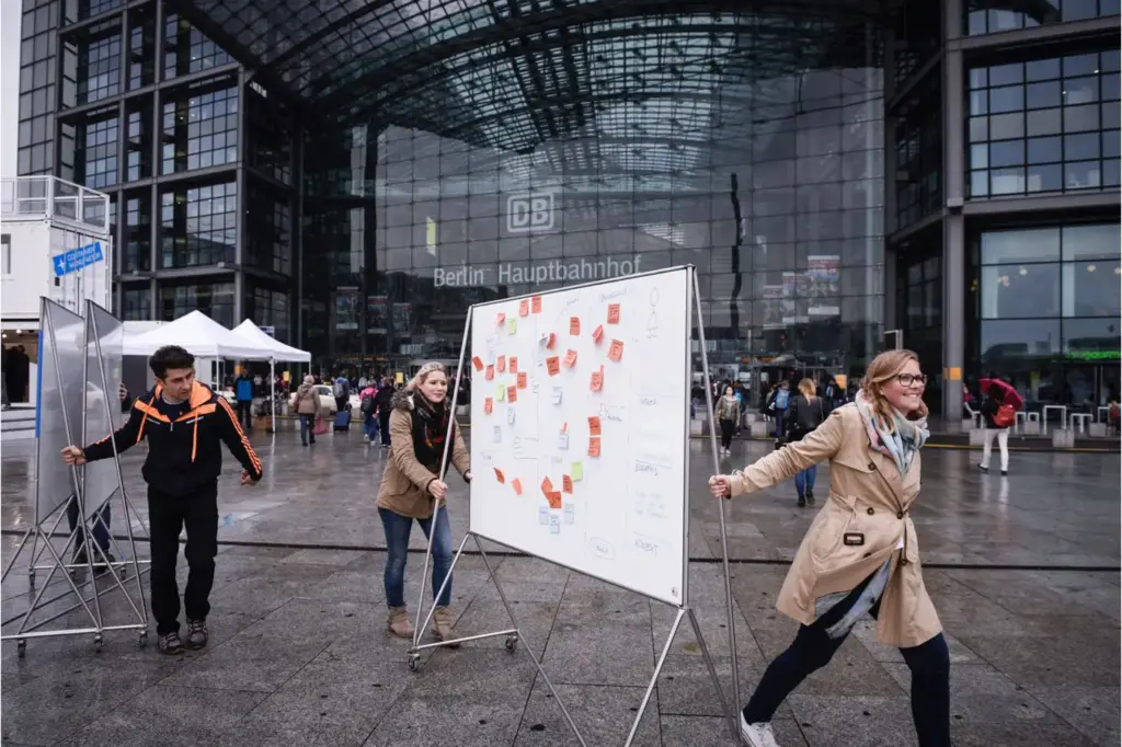 Ein Whiteboard, typisch für die Arbeit mit Design Thinking, wird über den Vorhof des Berliner Bahnhofs gerollt