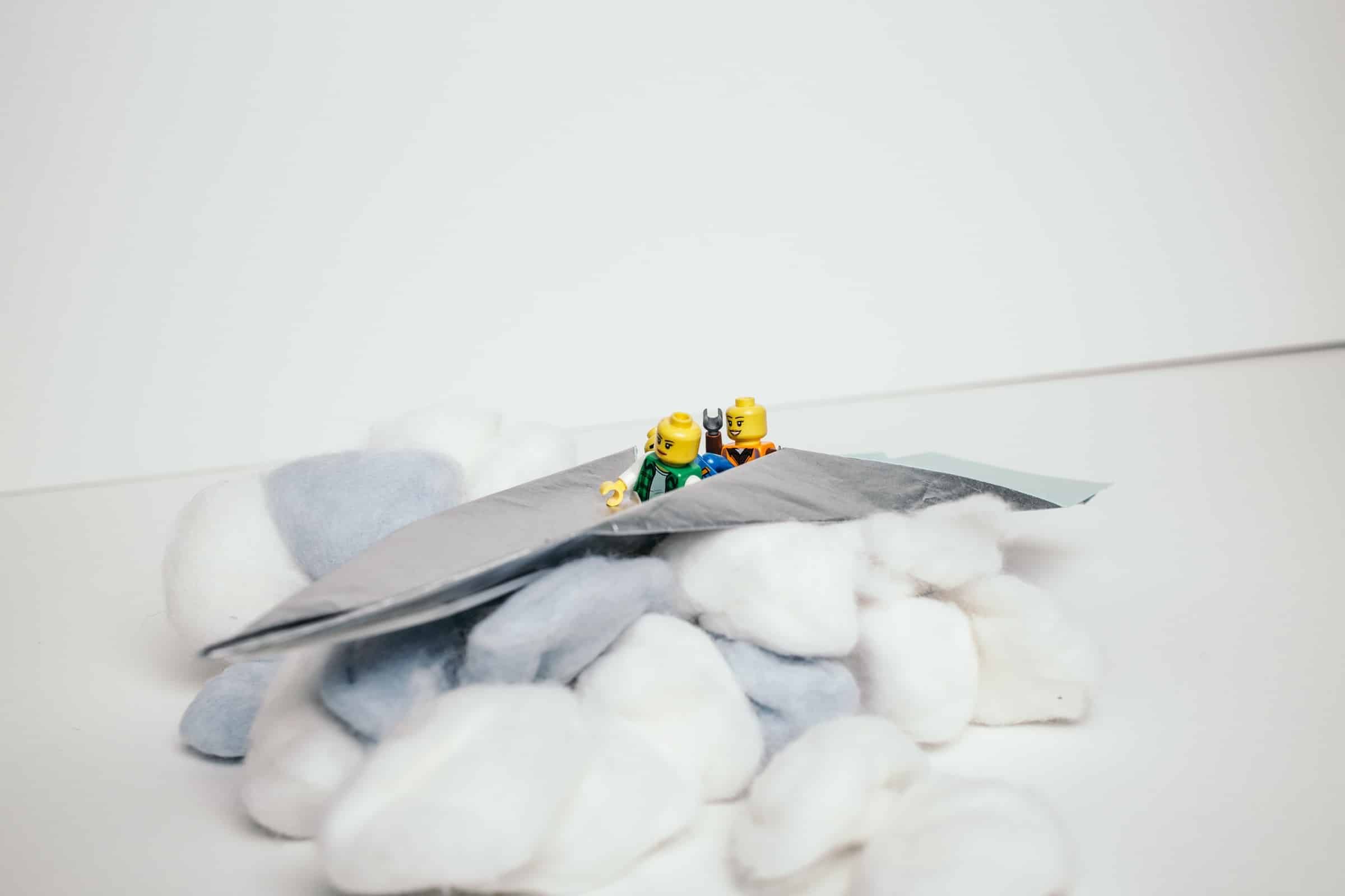Symbolbild für Teamentwicklung mit Papierflieger und LEGO®-Figuren